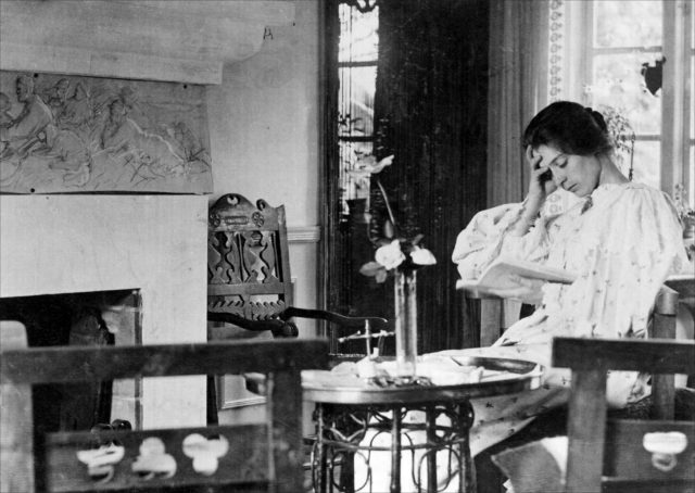 Marie Krøyer læsende ved kaminen